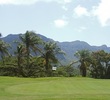 The par-5 11th hole's green at Puakea Golf Course is guarded by trees and a hillside on the right.